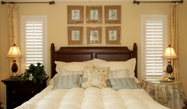 Beige bedroom with white plantation shutters covering windows in Phoenix 